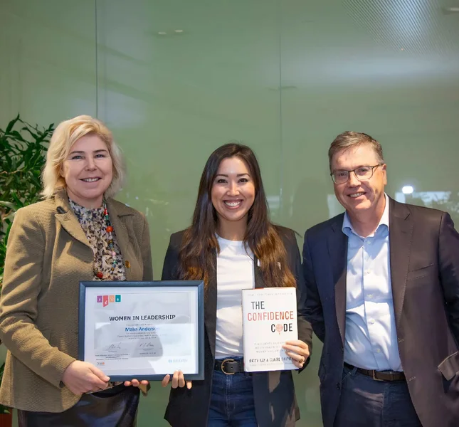 Employee is holding her diploma after having completed Gildan's Women in Leadership program.