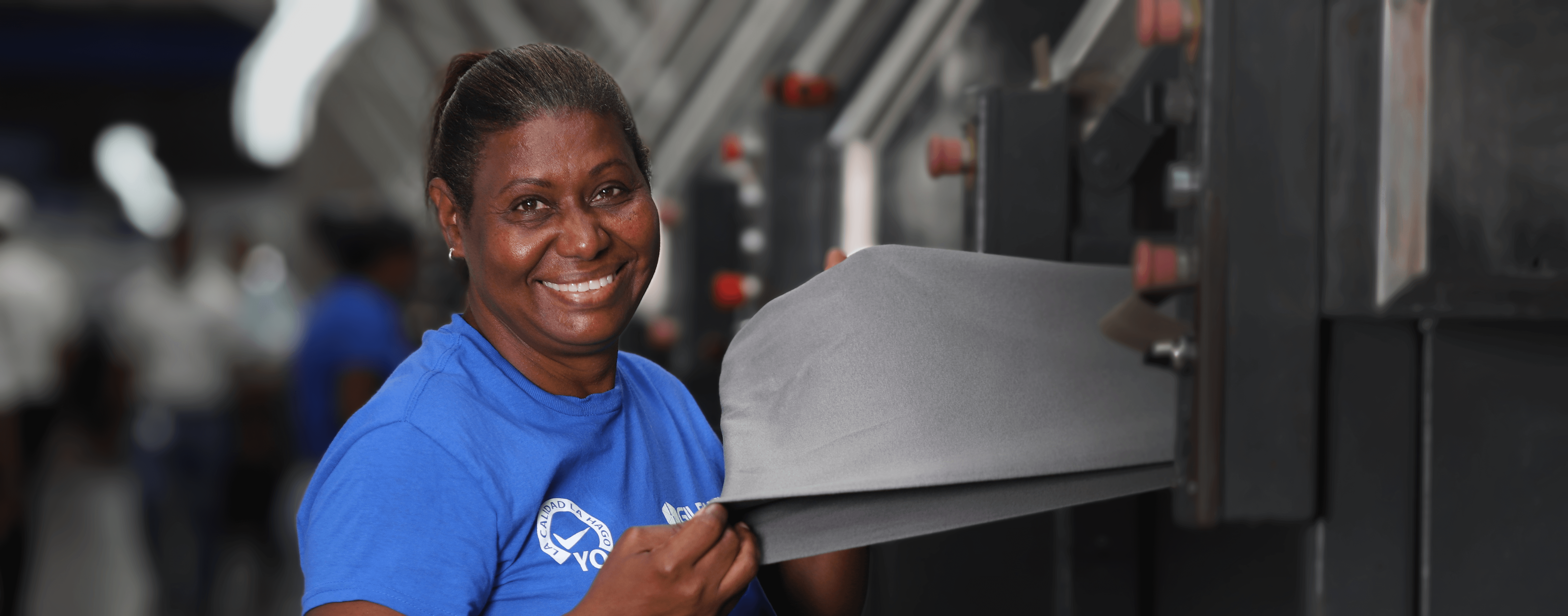 A male and female employee wearing Gildan shirts are smiling at the camera