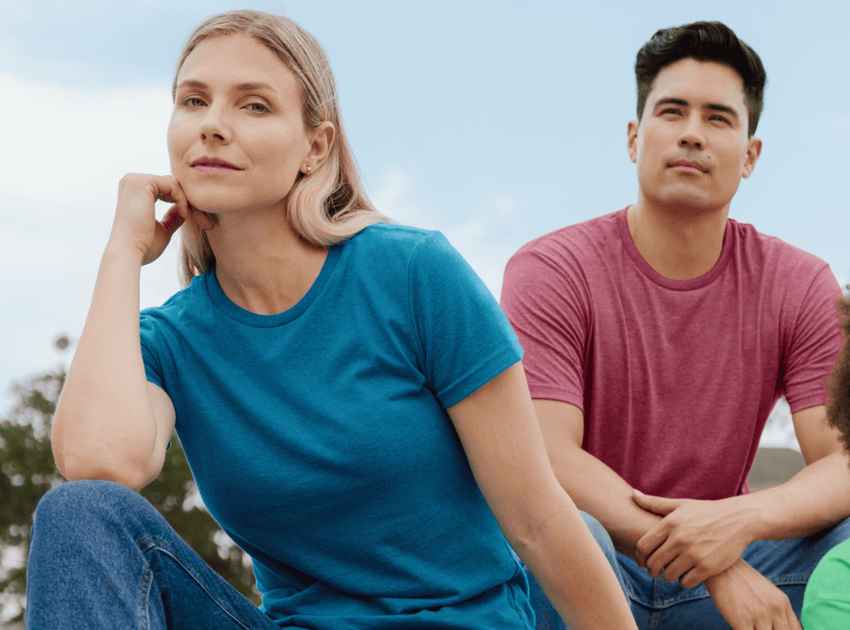 A woman sitting on bleachers outside wearing a blue shirt and jeans.
