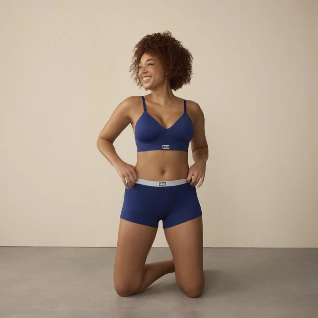 A woman wearing navy-colored bra and underwear.