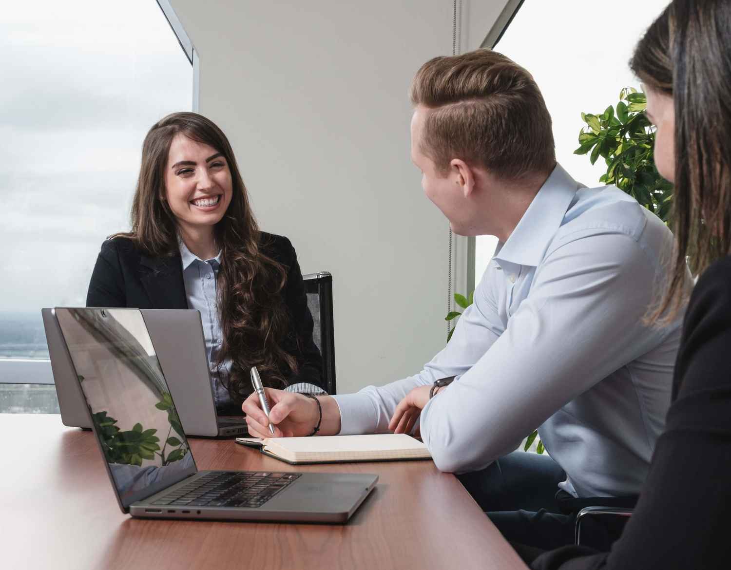 Employees in a meeting laughing.