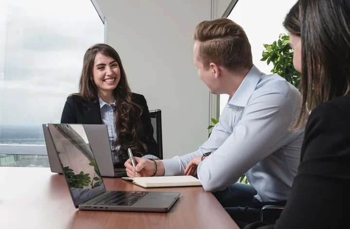 Des employés en réunion qui rient.