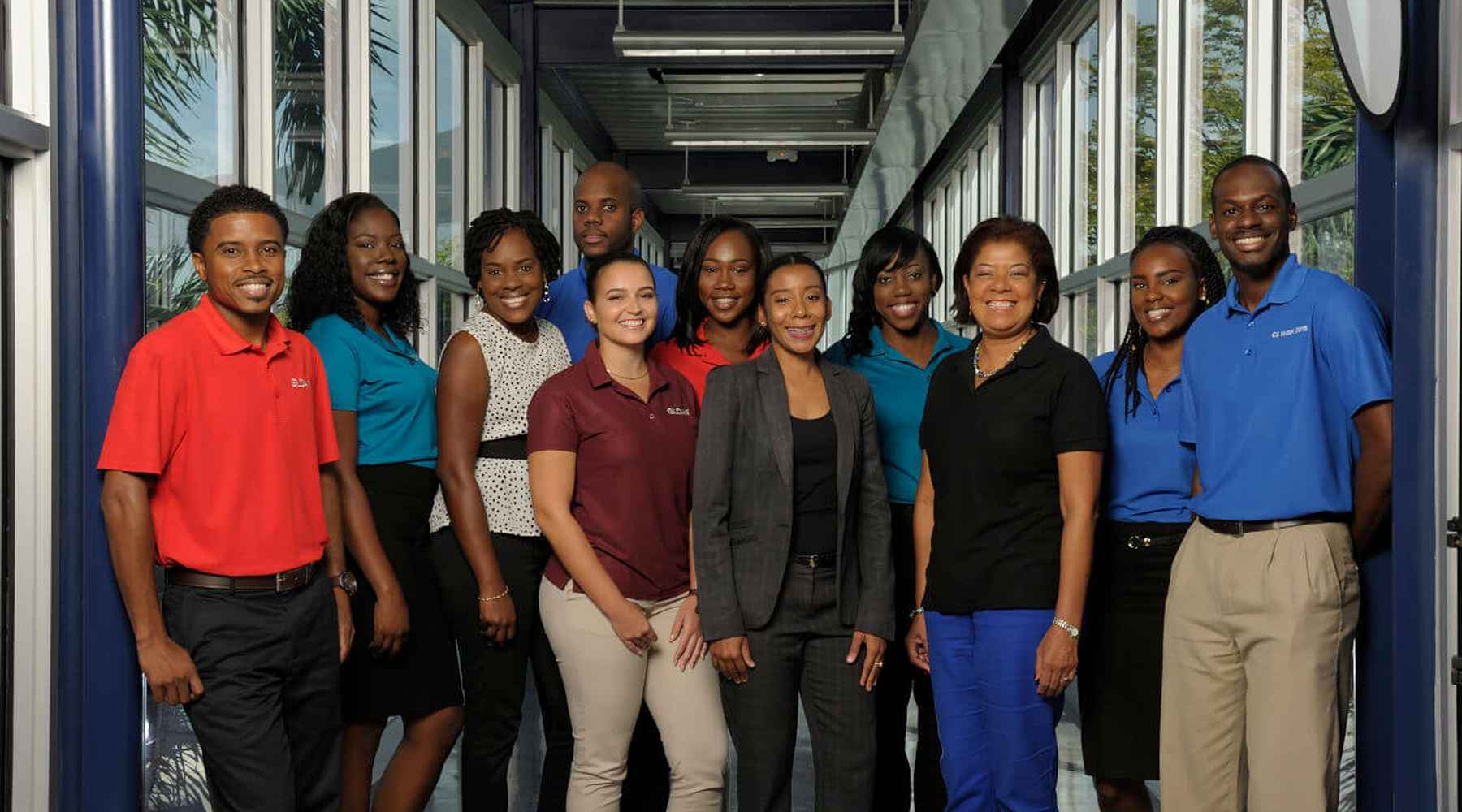 10 Gildan employees from Barbados are smiling at the camera.