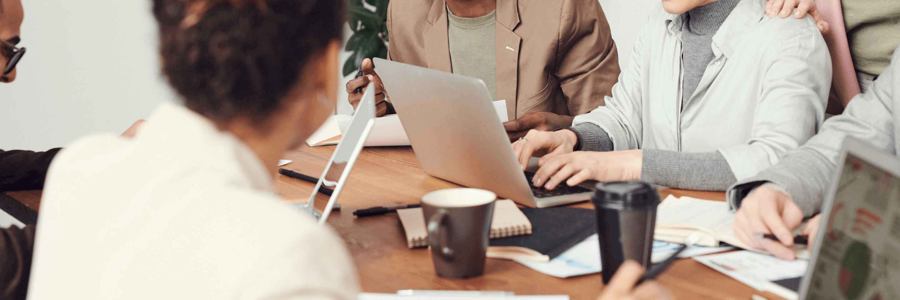 Office employees are sitting at a desk and working together.