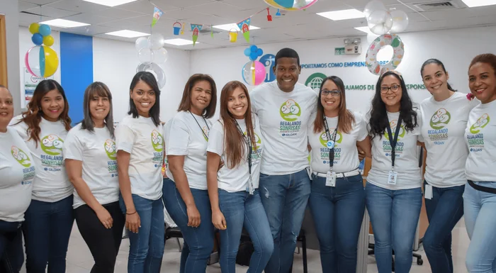 10 employees are wearing matching Gildan shirts and smiling at a volunteering event.