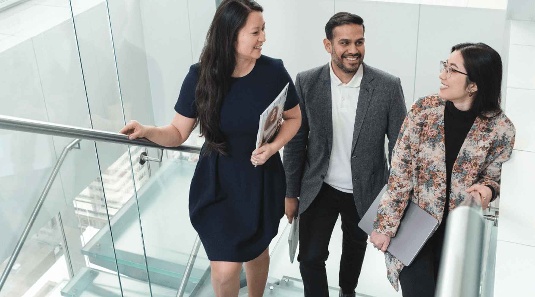 Three Gildan employees are walking up the stairs together at corporate head office.