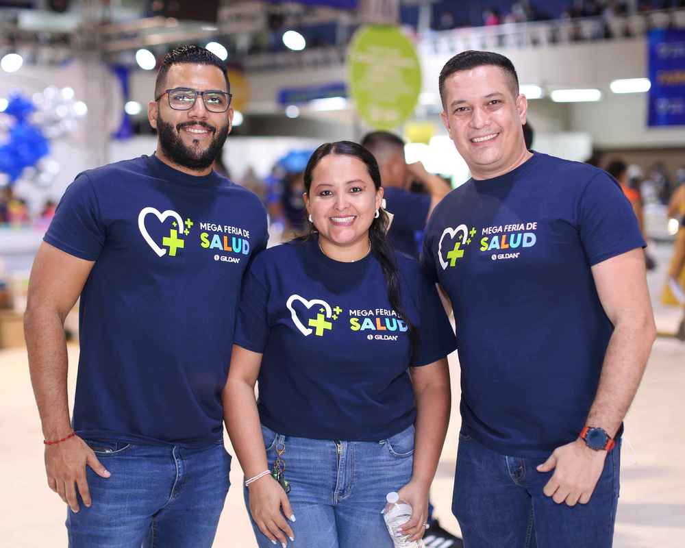 Trois employés portent des t-shirts Gildan bleu marine et sourient à la caméra.