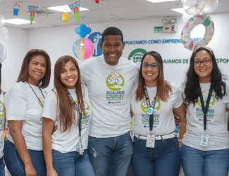 Five employees from the Dominican Republic are smiling at the camera at a volunteering event.