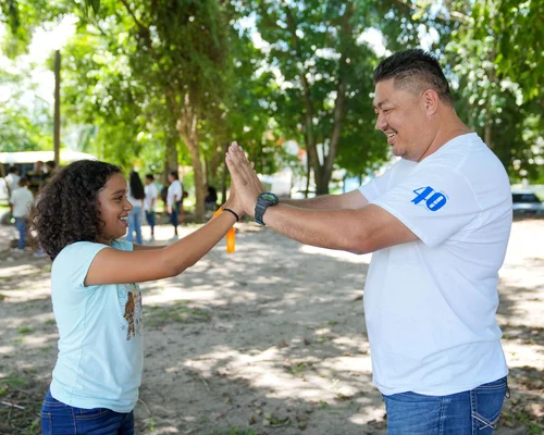 Employees from Nicaragua are standing on the beach and smiling after cleaning up.