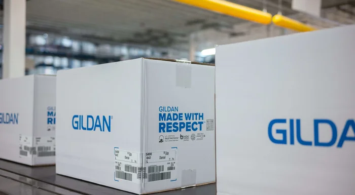 Las cajas de Gildan Made With Respect bajan por una cinta transportadora.