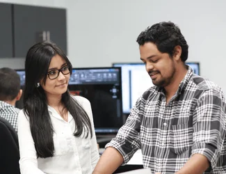 Two employees from Nicaragua are looking at a piece of paper on a table.