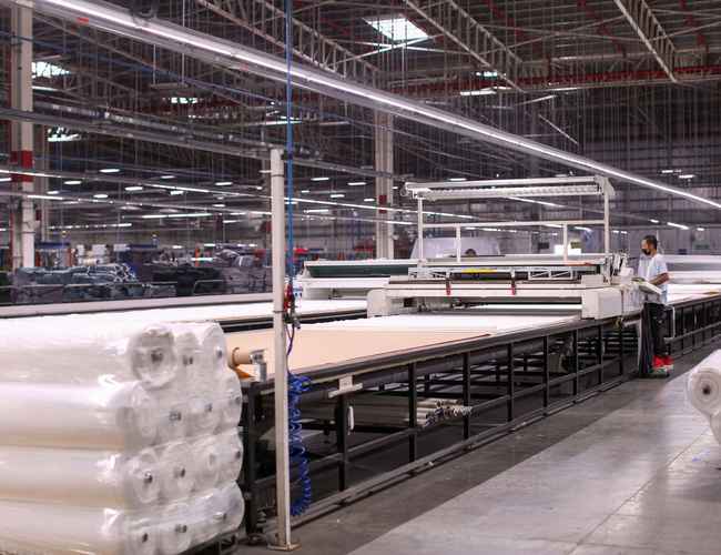 L'usine textile de Gildan où le tissu est déroulé pour être coupé.