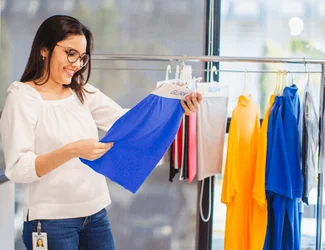 Una mujer en la sala de exposición está mirando un trozo de tela Gildan.