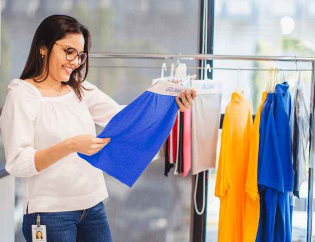 A woman in the showroom is looking at a piece of Gildan fabric.