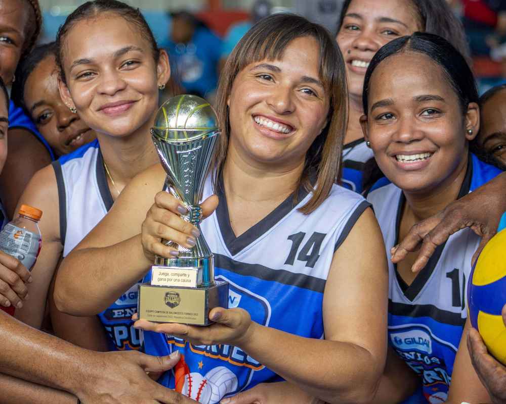 Gildan employees and holding a basketball trophy while wearing their blue and white jerseys.