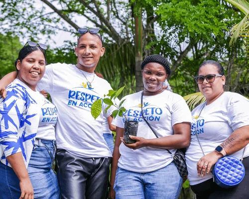 Una foto grupal de empleados de Nicaragua parados afuera con camisetas verdes de Gildan.