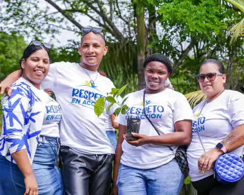 A group photo of employees from Nicaragua standing outside wearing green Gildan t-shirts.