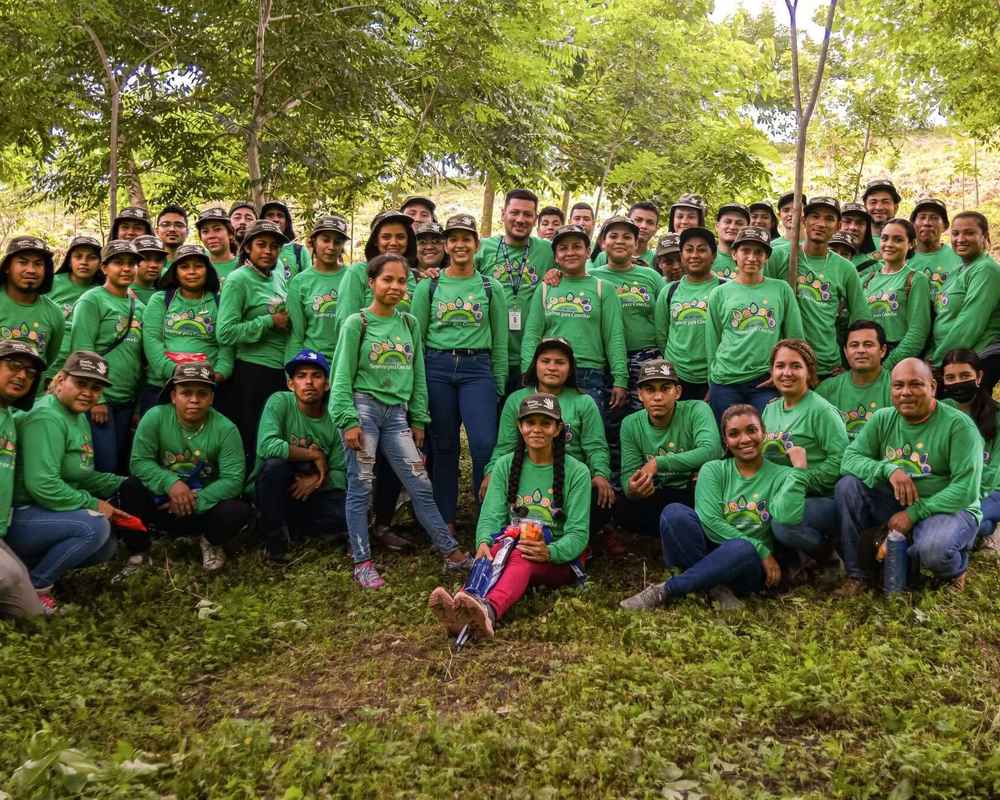 A group photo of employees from Nicaragua standing outside wearing green Gildan t-shirts.