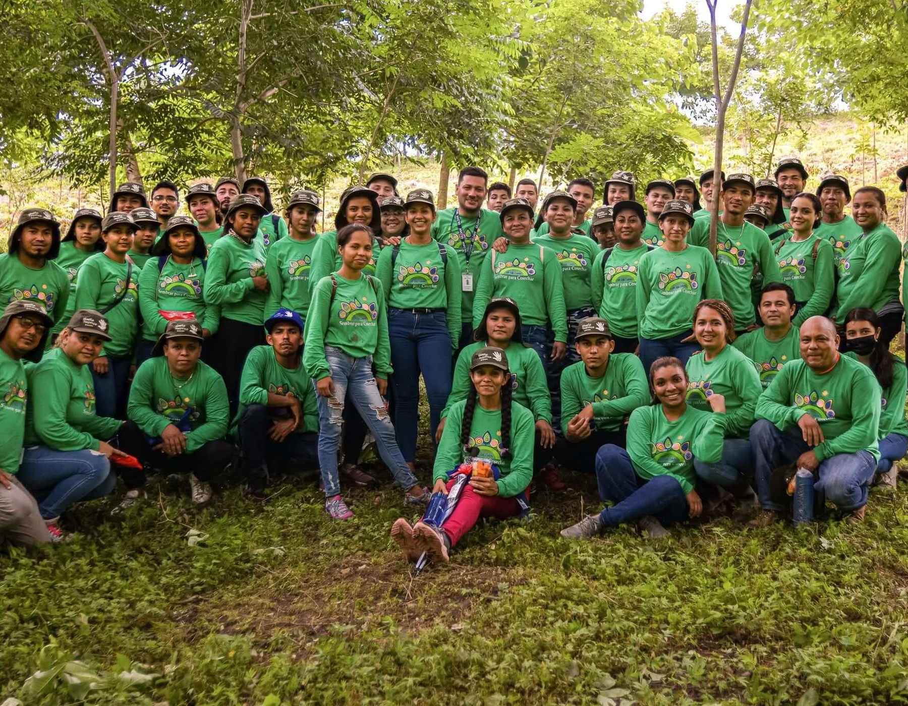 A group photo of employees from Nicaragua standing outside wearing green Gildan t-shirts.