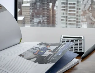 A close-up image of a report, with a calculator in the background.