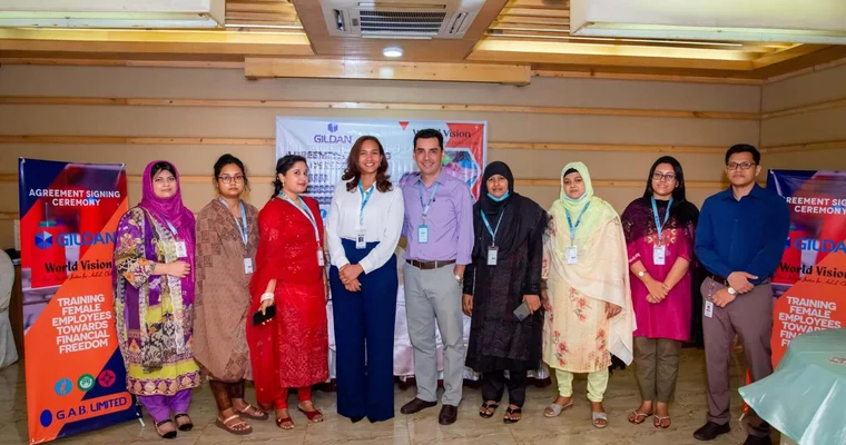 Los empleados de Gildan y Karina Valenzuela, Directora de Recursos Humanos en Bangladesh, sonríen.